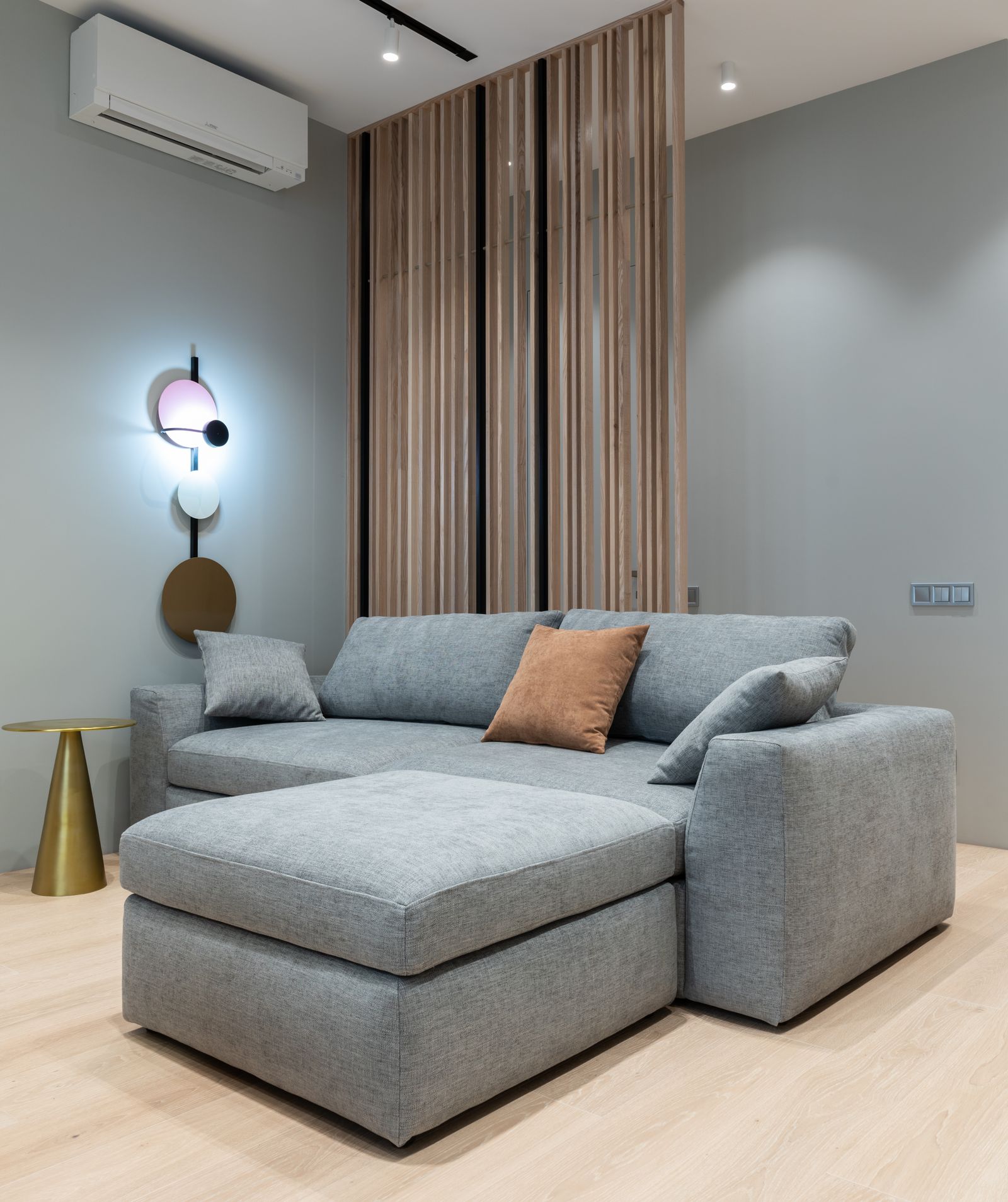 Wall-mounted split unit above a living room sofa